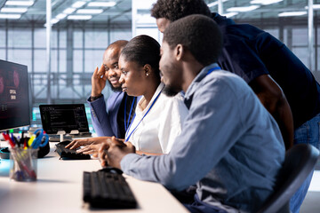 Team of engineers in server hub working together to investigate breach alerts, working to protect equipment from hacker. Colleagues doing brainstorming in data center to mitigate security risks