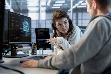 Software developers using tablet in data center, coordinating deployment of server architecture,...