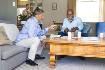 Playing board game, African American men on couch having friendly conversation