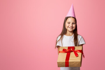 Is it for me. Little kid girl in cap hold gift box and big, isolated on pink background, free space