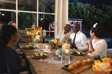 African American family sharing stories and laughter during dinner at table