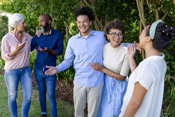 Friends and family celebrating outdoors, sharing joyful moments at wedding event