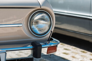 Round Headlight and Chrome Bumper of Beige Classic Car – Close-Up