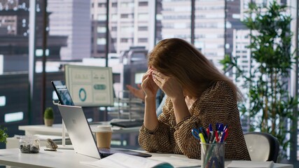 Successful woman battles a headache while managing her financial projects for the enterprise. Employee deals with pressure of meeting objectives, deadlines lead to mental exhaustion. Camera A.
