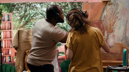 In modern studio, diverse painters using oil paints to create rustic masterpiece. Creative process involves meticulous brushwork, mixing colors to create fine art for gallery exhibition. Camera A.