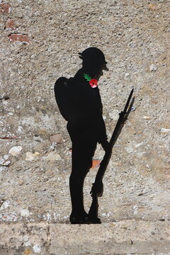 Soldier silhouette with poppy against stone wall of church, Great Easton (a village and civil parish in the Uttlesford district), Essex, England