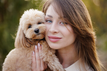 Close-up of woman and cute dog cuddling, showing love, happiness, and connection.