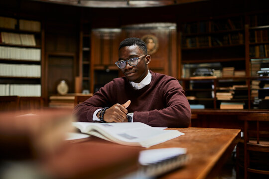 Portrait of a young african male student studying in a university library