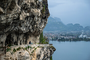 view of a mountain trail in the dolomites with lago di garda in the background