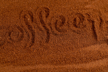 The word coffee written on a ground coffee for preparation of a drink, roasted ground coffee in large quantities