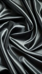 Fototapeta premium Smooth, soft, shiny black silk satin fabric with a rippled texture creates an elegant and luxurious backdrop