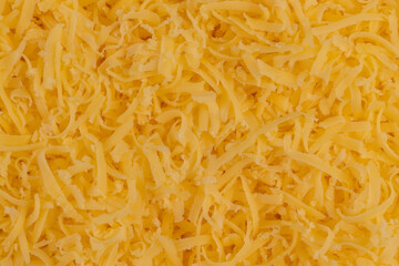 grated hard cheese of orange color, grated cheese preparation for adding to dishes, close up