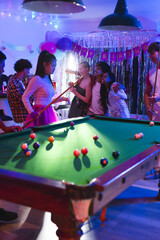 Fototapeta premium Teenagers playing pool at birthday party, enjoying festive celebration with friends