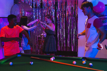 Teenagers dancing joyfully at party with pool table and disco ball © wavebreak3