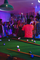 Fototapeta premium Celebrating around pool table, teenagers with drinks in festive party atmosphere