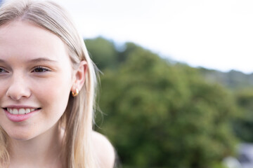 Naklejka premium Teen girl smiling outdoors, enjoying nature and fresh air in park