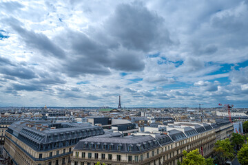 Panoramic View of Paris Rooftops with Eiffel Tower Under Dramatic Cloudy Sky