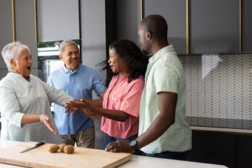 Selbstklebende Fototapeten Three generations in kitchen preparing meal, sharing laughter and joyful moments © WavebreakMediaMicro