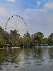 Fototapeta premium The fortune of being well: People enjoying a revitalising walk, with the imposing presence of the Ferris wheel reminding us of the endless possibilities of enjoying the outdoors.