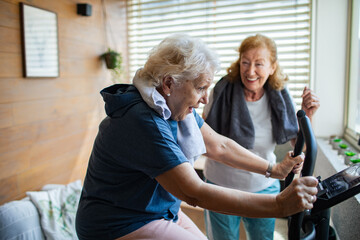 Senior lesbian couple exercising together at home and cheering each other on