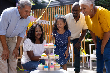 Celebrating birthday outdoors, family with cupcakes, smiling and cherishing moment together
