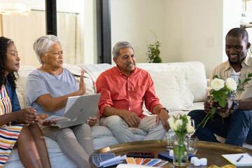 Family gathering at home, sharing stories and laughter while exchanging flowers