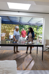 African American family enjoying conversation while preparing food together at home