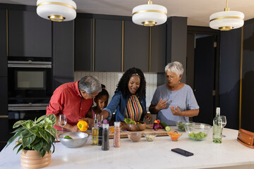 Family preparing meal together in modern kitchen, sharing joyful moments