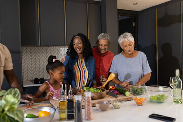 Preparing meal together, three generations of African American family in kitchen © WavebreakMediaMicro