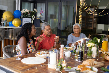 Family enjoying dinner together, sharing stories and laughter at festive table