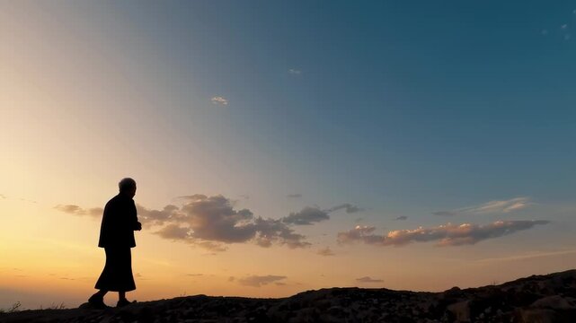 Buddhist monk walking alone at sunset across barren hills under wide open sky. Solitude, purpose, mindfulness, spiritual journey and inner transformation. 
