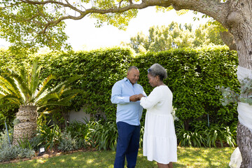 Senior couple dancing together in garden, enjoying sunny day outdoors © wavebreak3