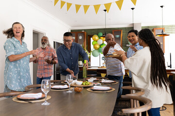 Diverse group of seniors celebrating at home, enjoying laughter and conversation