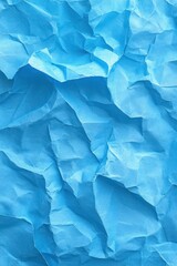 Obraz premium Close-up view of crumpled light blue paper with irregular folds and creases creating textured surface