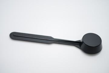 Black plastic spoon for measuring ground coffee