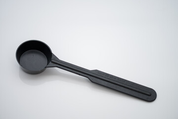 Black plastic spoon for measuring ground coffee
