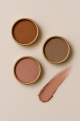 Fototapeta premium Sustainable plastic-free eyeshadow in earth tone pots on paper background