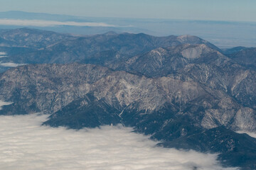 Aerial view of the San Gabriel Mountains outside of Los Angeles featuring Mt Baldy and Mt San Antonio with clouds covering the Pomona Valley