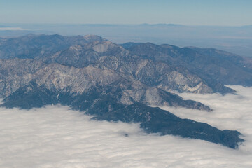 Aerial view of the San Gabriel Mountains outside of Los Angeles featuring Mt Baldy and Mt San Antonio with clouds covering the Pomona Valley