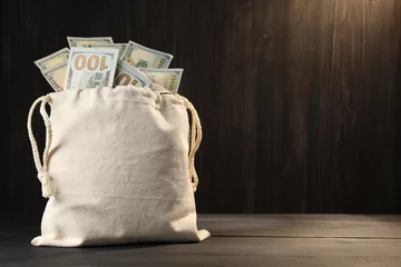 Zelfklevend Fotobehang Money bag with dollar banknotes on wooden table, space for text © New Africa
