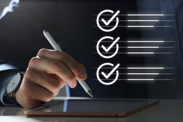 Approved. Man using tablet at table, closeup. Check marks above device