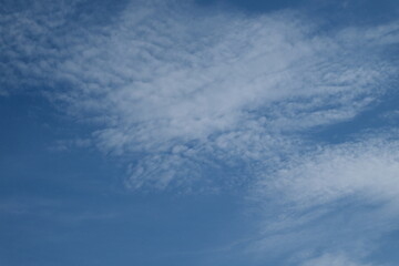 clear blue sky with a few clouds. The sky is very bright and the clouds are scattered throughout