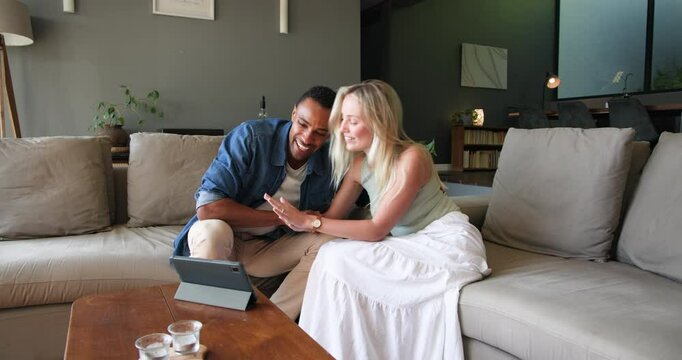 Happy black man and his white female partner smiling and showing engagement ring on tablet video cha