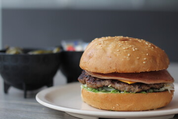 This freshly grilled burger is loaded with a juicy patty, fresh lettuce, and melty cheese, served alongside crispy pickles, making it a classic comfort food option.