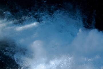 Close-up image of intense river rapids with foaming whitewater and deep blue currents. Dynamic and...
