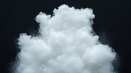 White powdery substance dispersing against a black background, creating a cloudy, mist-like effect.