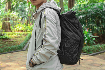 Young man wearing a hoodie jacket and black backpack