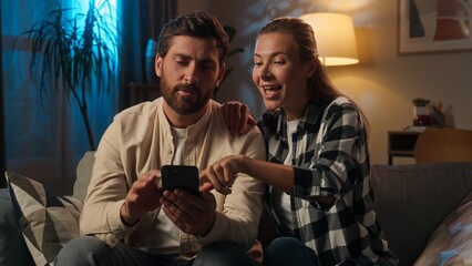 Affectionate couple husband wife Caucasian happy family woman man buyers homeowners girl guy discuss choosing purchase mobile phone buying online shopping repair home evening talking order smartphone