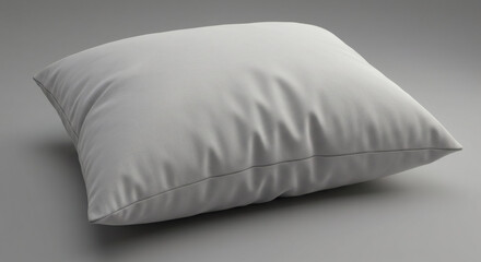 A pristine white square pillow presents softness and comfort against a simple gray backdrop.