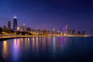 Obraz premium Chicago skyline at night, architecture reflecting lights in water, urban cityscape